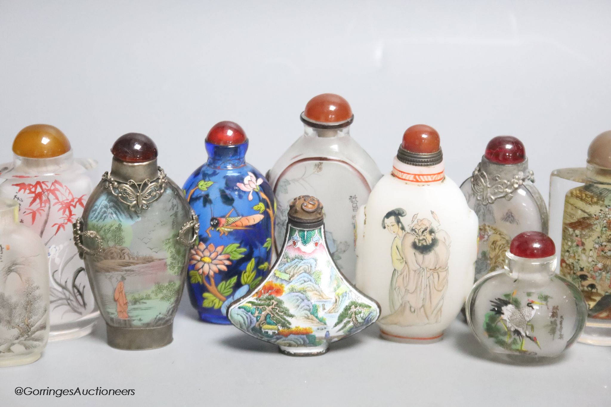 Eleven Chinese painted glass snuff bottles, a glass enamel one and another enamel one